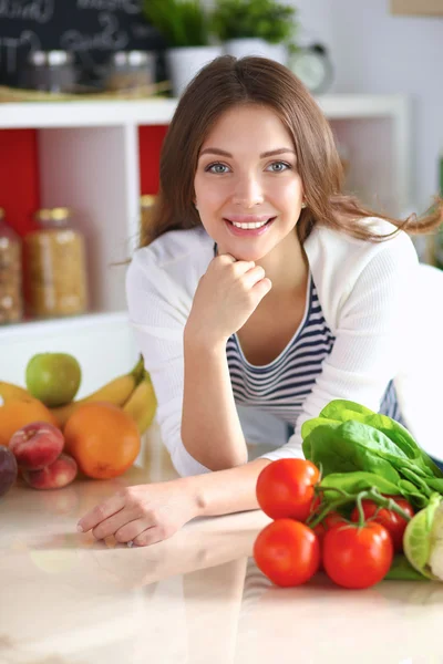 Junge Frau steht neben Schreibtisch in der Küche — Stockfoto