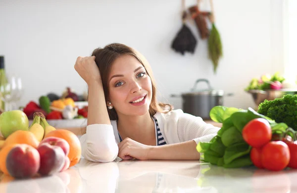 Jovem mulher de pé perto da mesa na cozinha — Fotografia de Stock