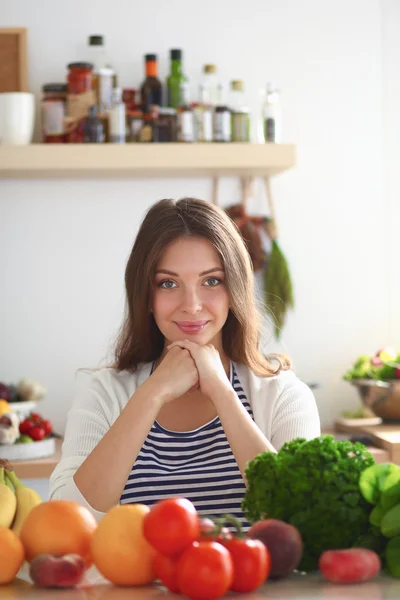 Jonge vrouw in de buurt van bureau in de keuken — Stockfoto