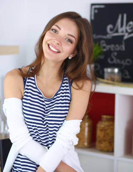 Young woman sitting in kitchen at home — Stock Photo, Image