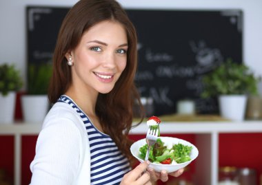 Salata yemek ve karışık salata tutan genç kadın