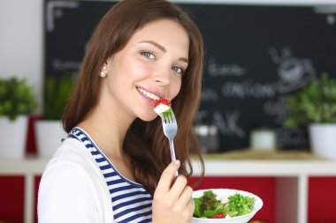 Salata yemek ve karışık salata tutan genç kadın