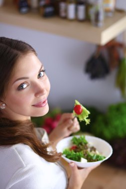 Salata yemek ve karışık salata tutan genç kadın