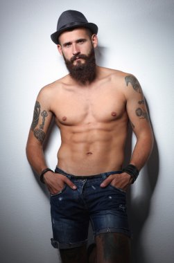 şapka ayakta, gri arka plan üzerinde izole yakışıklı sakallı adam portresi