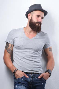 şapka ayakta, gri arka plan üzerinde izole yakışıklı sakallı adam portresi