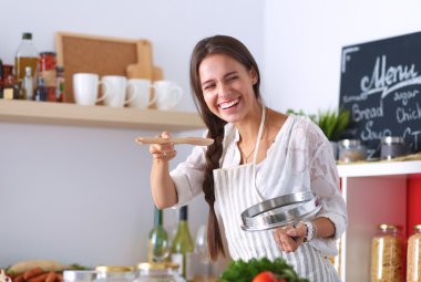 Mutfakta ahşap kaşıkla yemek pişiren kadın