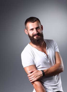 Ayakta, gri arka plan üzerinde izole yakışıklı adam portresi