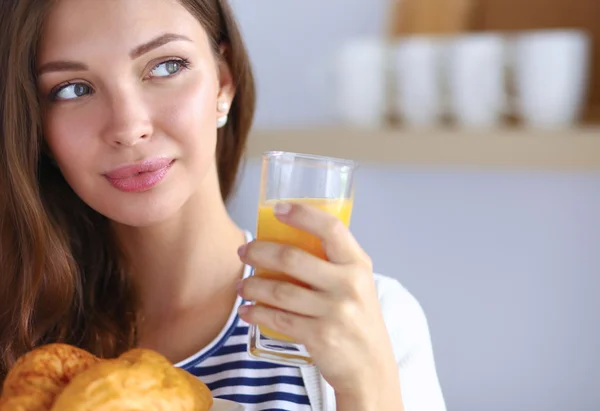 Jeune femme avec un verre de jus et des gâteaux — Photo