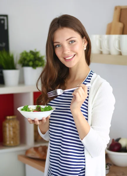 Salata yemek ve karışık salata tutan genç kadın