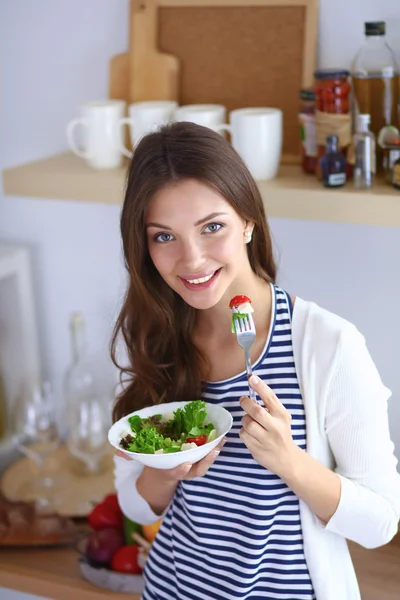 Salata yemek ve karışık salata tutan genç kadın