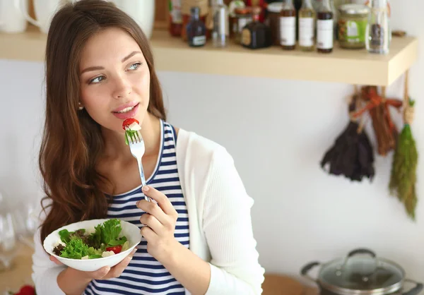 Salata yemek ve karışık salata tutan genç kadın