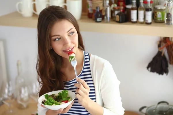 Jonge vrouw salade eten en het bedrijf van een gemengde salade — Stockfoto