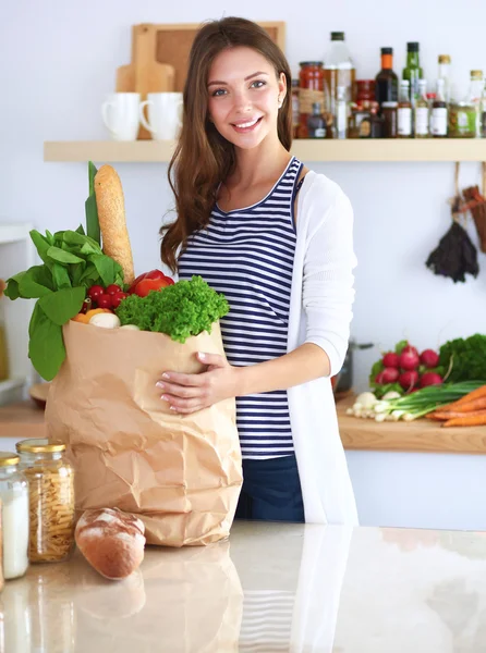 Junge Frau hält Einkaufstüte mit Gemüse — Stockfoto