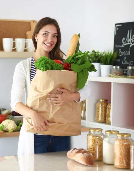 Young woman holding grocery shopping bag with vegetables — Stock Photo, Image