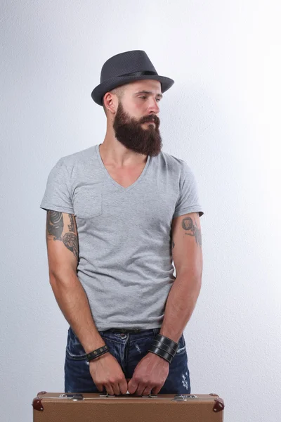 Портрет красивого бородатого чоловіка в капелюсі, що стоїть з поганим, ізольовано на білому тлі — стокове фото