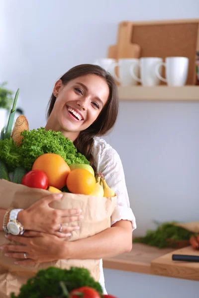 Young woman holding grocery shopping bag with vegetables — Stock Photo, Image