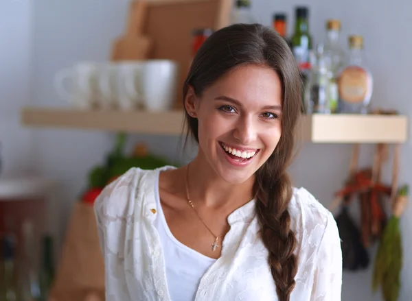 Jonge vrouw in de buurt van bureau in de keuken — Stockfoto