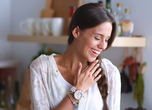 Jonge vrouw in de buurt van bureau in de keuken — Stockfoto