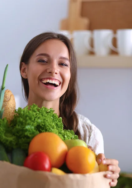 Ung kvinna med livsmedelsbutiker shoppingväska med grönsaker och frukt — Stockfoto