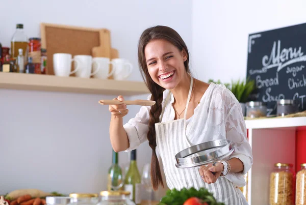 Mujer cocinera en cocina con cuchara de madera —  Fotos de Stock