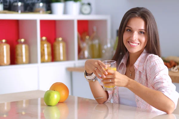 Junge Frau sitzt an einem Tisch in der Küche — Stockfoto