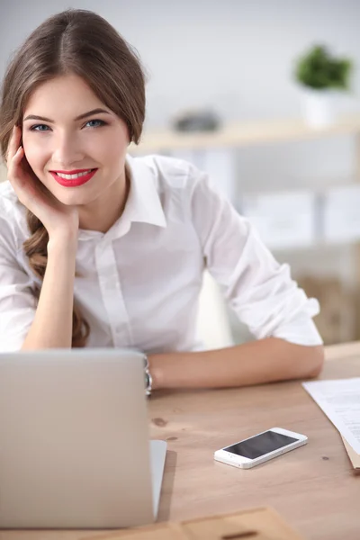 Attraktive Geschäftsfrau sitzt auf Schreibtisch im Büro — Stockfoto