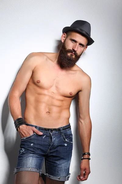 şapka ayakta, gri arka plan üzerinde izole yakışıklı sakallı adam portresi