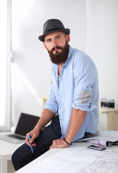 机に青写真と帽子の男性デザイナーの肖像画 — ストック写真