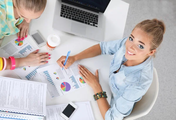 Due donne che lavorano insieme in ufficio, sedute sulla scrivania — Foto Stock