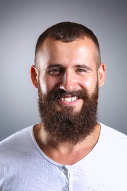 Ayakta, gri arka plan üzerinde izole yakışıklı adam portresi