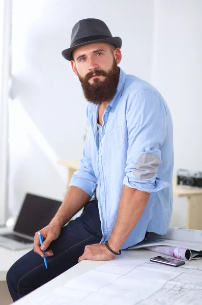 Retrato de diseñador masculino en sombrero con planos en el escritorio —  Fotos de Stock