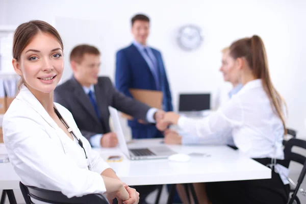 Hermosos jóvenes empresarios con colegas discutiendo en el fondo —  Fotos de Stock