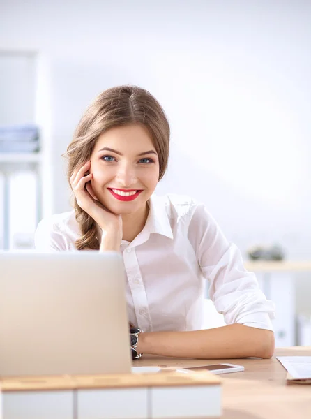 Aantrekkelijke zakenvrouw zit op het bureau in het kantoor — Stockfoto