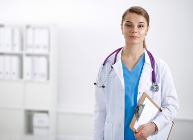 Kadın doktor hastanede dosyayla bekliyor.