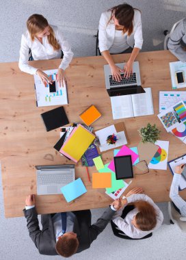 İş adamları iş toplantısında, ofiste oturup tartışıyorlar.