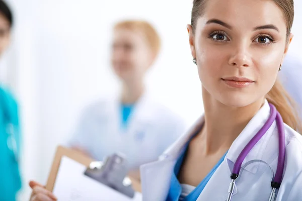 Attractive female doctor in front of medical group — Stock Photo, Image