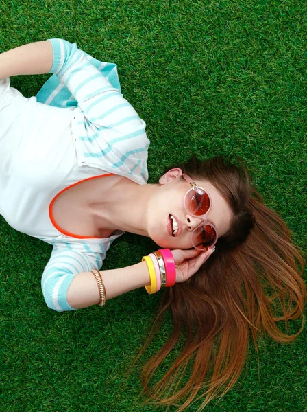 Hermosa joven mujer haciendo selfie por su teléfono mientras se encuentra en la hierba verde — Foto de Stock
