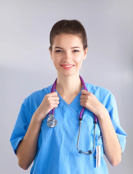 Jeune médecin femme avec stéthoscope isolé sur gris — Photo