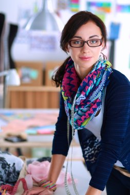 Güzel moda tasarımcısı stüdyoda duruyor.