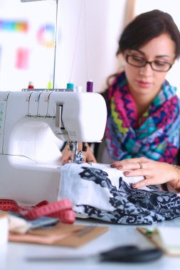 Çalışırken dikiş diken genç bir kadın.