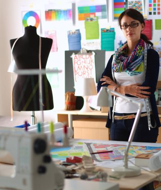 Güzel moda tasarımcısı stüdyoda duruyor.