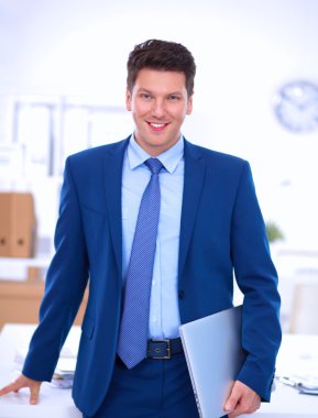 Ofiste masasının karşısında duran bir iş adamı ya da yönetici.