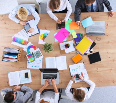 İş adamları iş toplantısında, ofiste oturup tartışıyorlar.