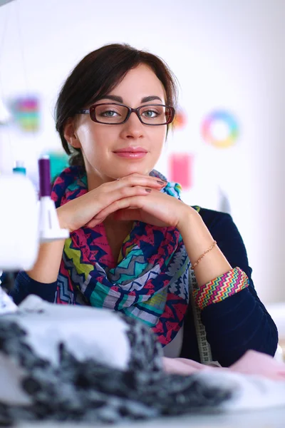 Beautiful fashion designer sitting at the desk in studio — Stock Photo, Image