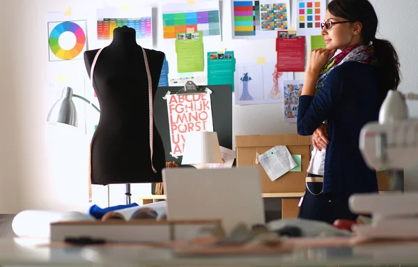 Schöne Modedesignerin steht im Atelier — Stockfoto