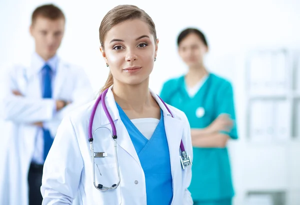 Attractive female doctor in front of medical group — Stock Photo, Image