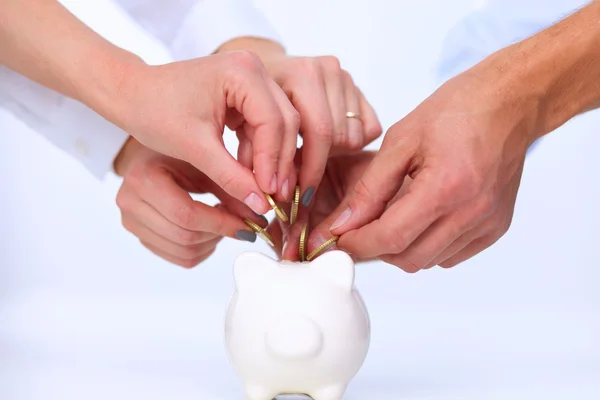 Gente poniendo moneda en la alcancía — Foto de Stock