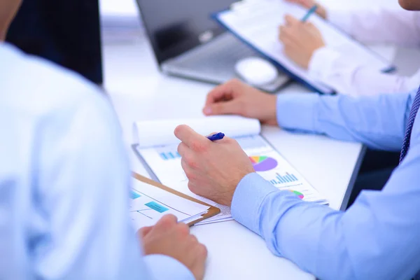 Zakenmensen zitten en schrijven op zakelijke bijeenkomst, in functie — Stockfoto