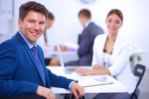 Hermosos jóvenes empresarios con colegas discutiendo en el fondo — Foto de Stock