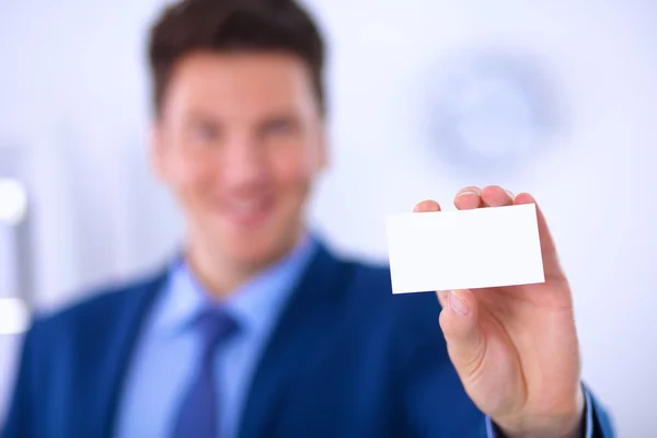 Retrato de un joven sosteniendo una tarjeta blanca en blanco — Foto de Stock